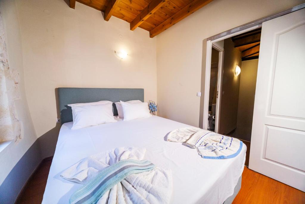 a bedroom with a bed with white sheets at Casa Stella in Chania Town