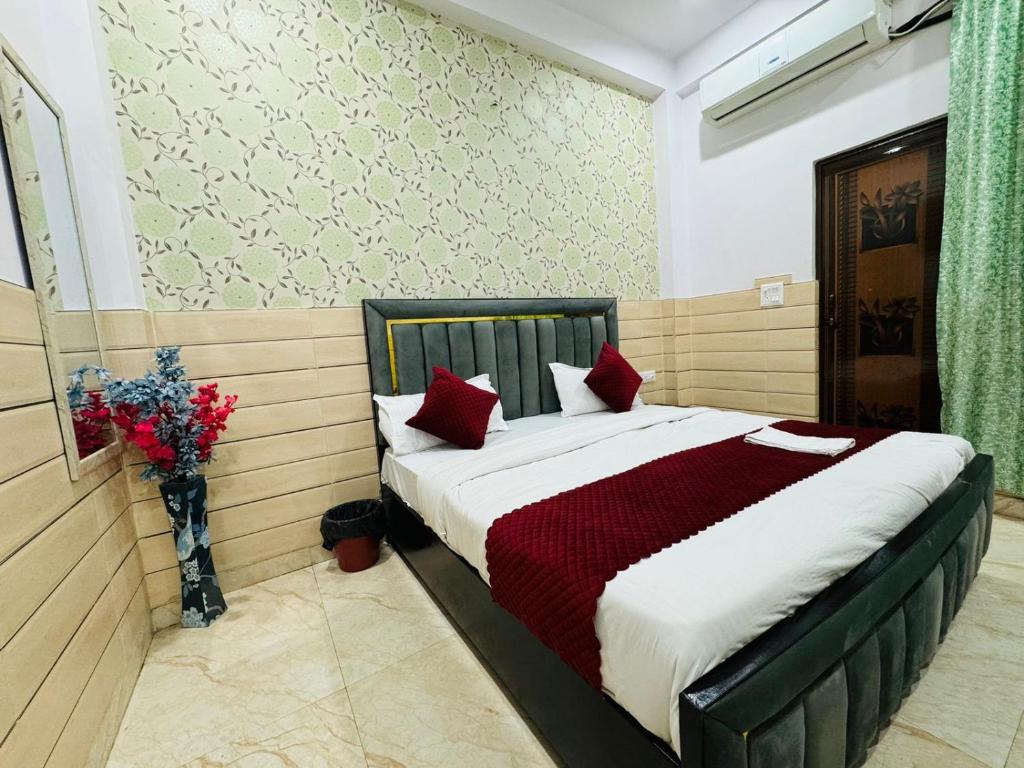 um quarto com uma cama grande e almofadas vermelhas em Hotel Sapphire Grand - Onyx Plaza em Ghaziabad