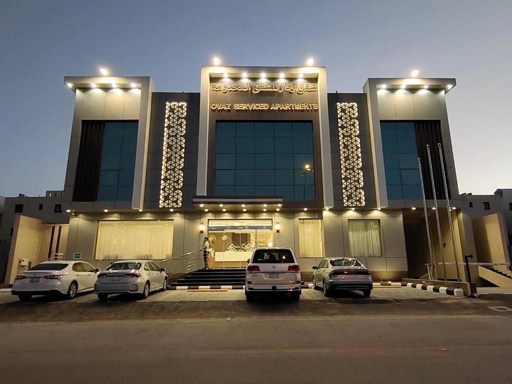 un gran edificio con coches estacionados frente a él en أوفاز للشقق المخدومة en Riad