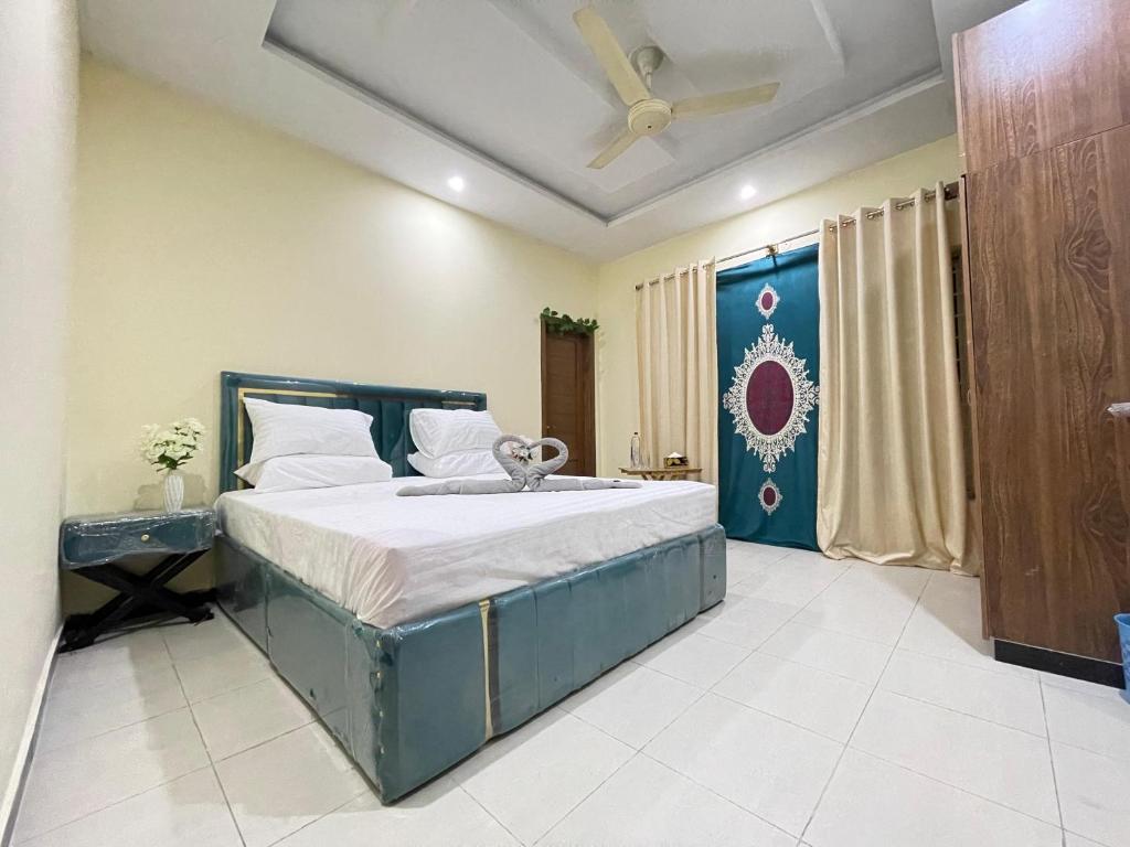 a bedroom with a large bed with a ceiling fan at Islamabad guest house in Islamabad