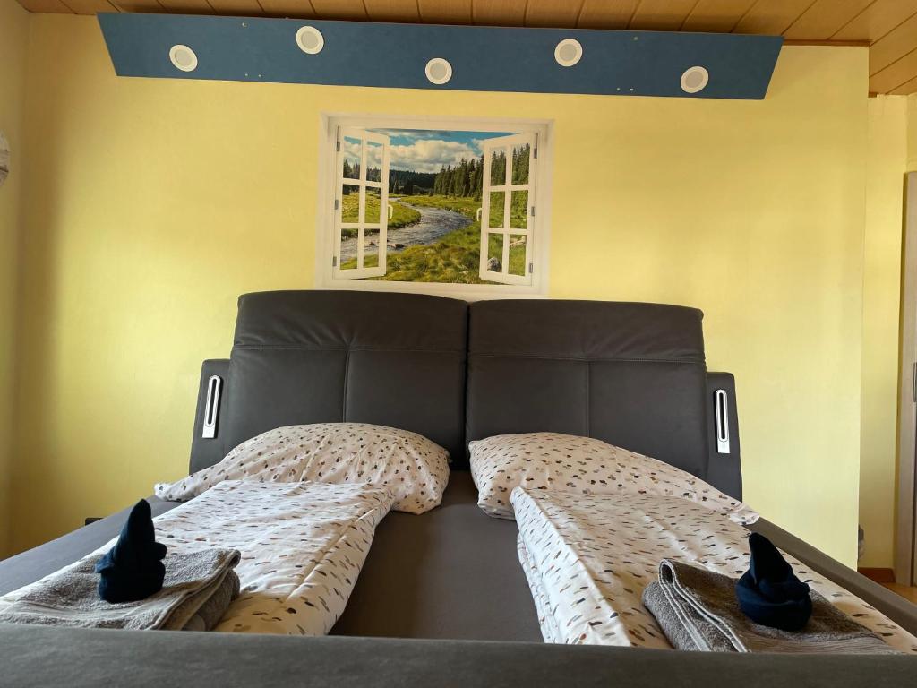 um quarto com uma cama com cabeceira e 2 janelas em Roomfortwo Natural em Waldsolms