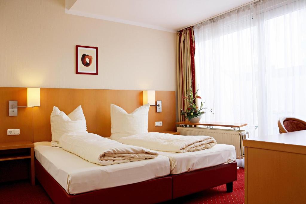 um quarto de hotel com duas camas com almofadas brancas em Air in Berlin em Berlim