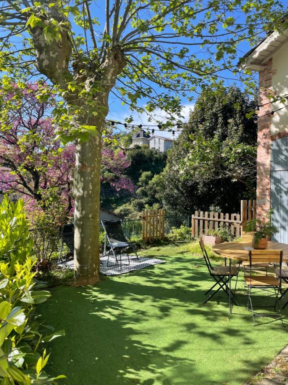 a garden with a table and chairs and a tree at Maison de charme avec jardin - Proche Lyon - in Vienne