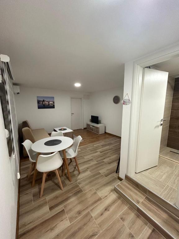 ein Wohnzimmer mit einem Tisch und Stühlen in einem Zimmer in der Unterkunft Apartman Dušan Trebinje in Trebinje