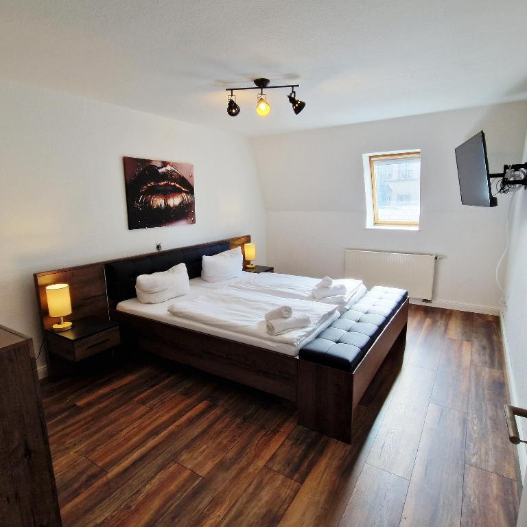 1 dormitorio con 1 cama grande y suelo de madera en DM Hotes & Apartments - Apartment Dosborn 2A, en Dingelstädt