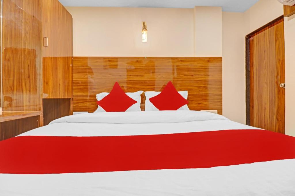 a bedroom with a large bed with red pillows at OYO Hotel Royal Park in Mumbai