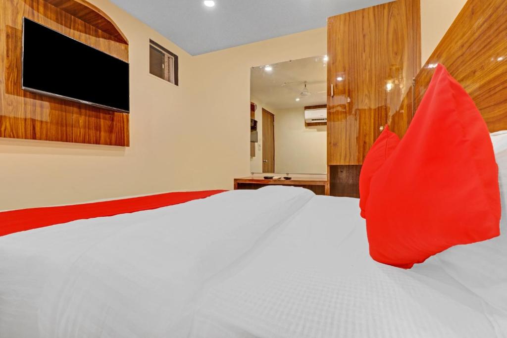 ein Schlafzimmer mit einem großen weißen Bett mit roten Kissen in der Unterkunft OYO Hotel Royal Park in Mumbai