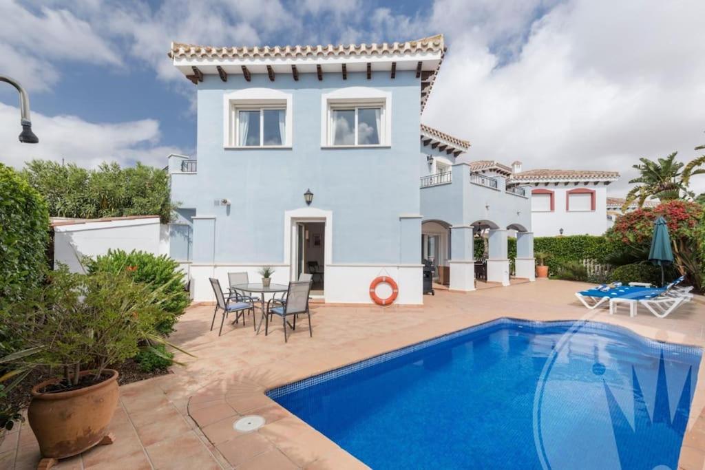 a villa with a swimming pool and a house at Mar Menor Golf Resort - 117 in Las Casicas