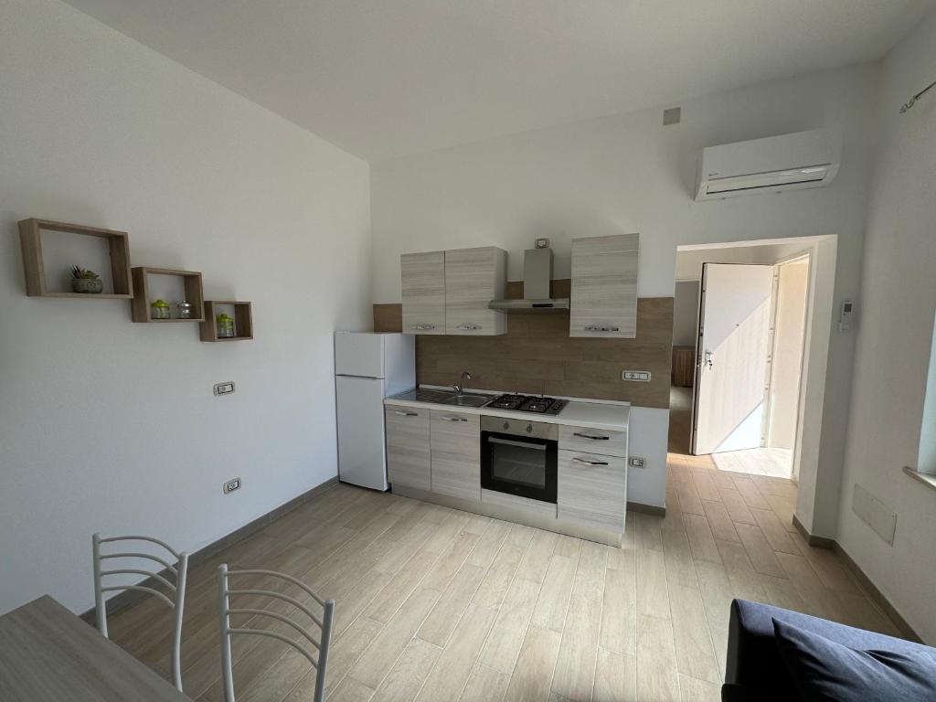 eine Küche mit weißen Geräten sowie einem Tisch und Stühlen in der Unterkunft B&B CARLO e ANNA in Ottava Sassari