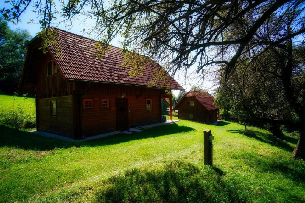 a large wooden house with a red roof on a field at Urlaub am Glatzl Bauernhof in Sankt Lorenzen am Wechsel