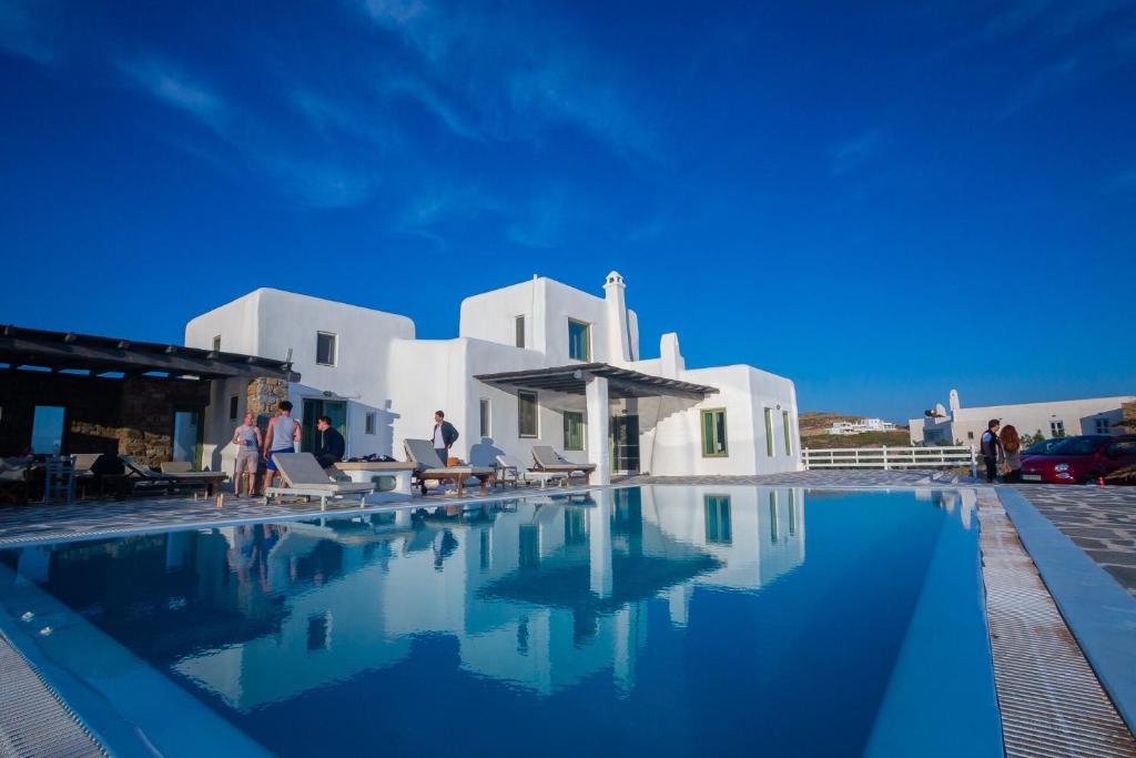 a swimming pool in front of a white building at Villa Irilia, Private Pool with Unrestricted Sea View in Fanari