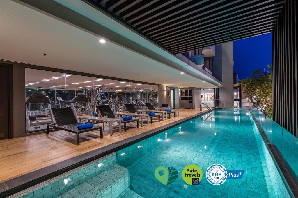 an indoor swimming pool with lounge chairs and a hotel at Aster Hotel and Residence by At Mind in Pattaya Central