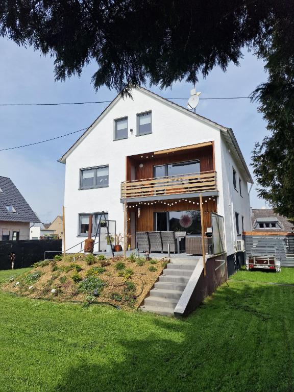 a white house with a porch on a lawn at Ut Huuske in Dorsel