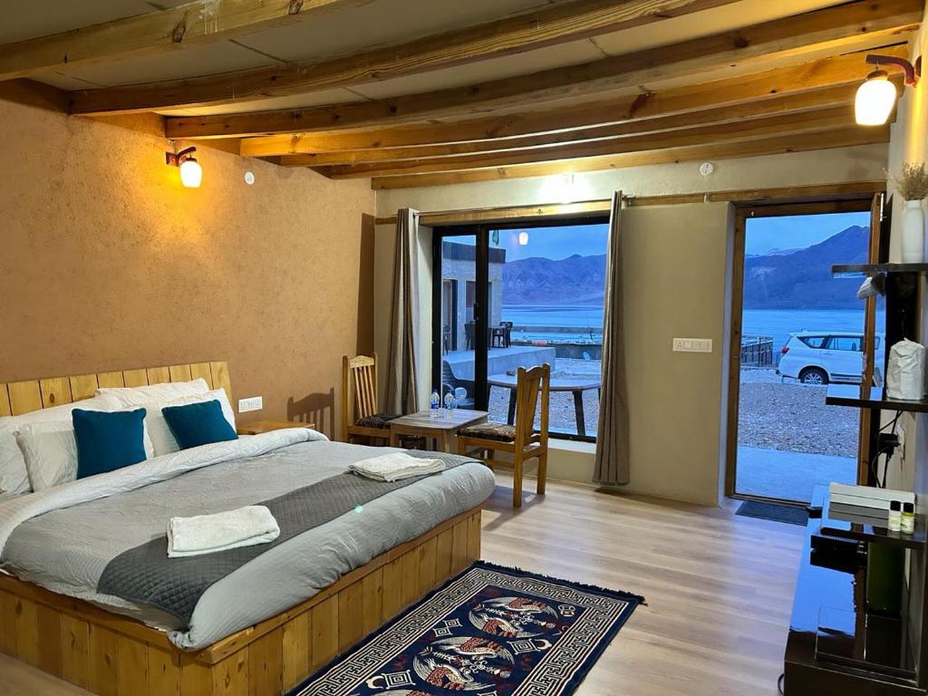 Schlafzimmer mit einem Bett und Blick auf das Wasser in der Unterkunft Mystic Pangong in Spangmik