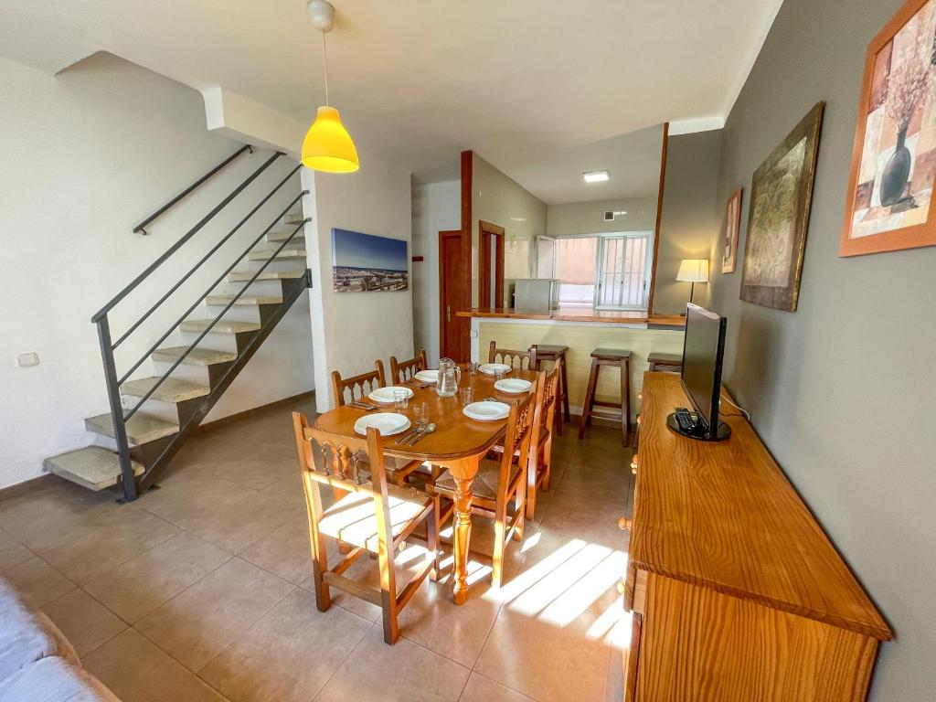 a dining room with a table with chairs and a television at Bungalows Pescador in Segur de Calafell