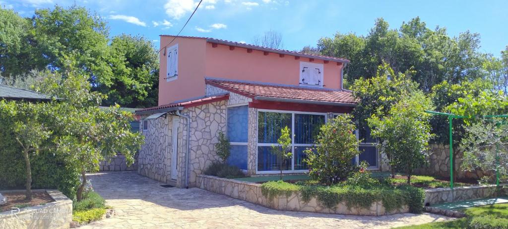 een klein roze huis met bomen ervoor bij House Vugrinec with garden and parking in Šišan