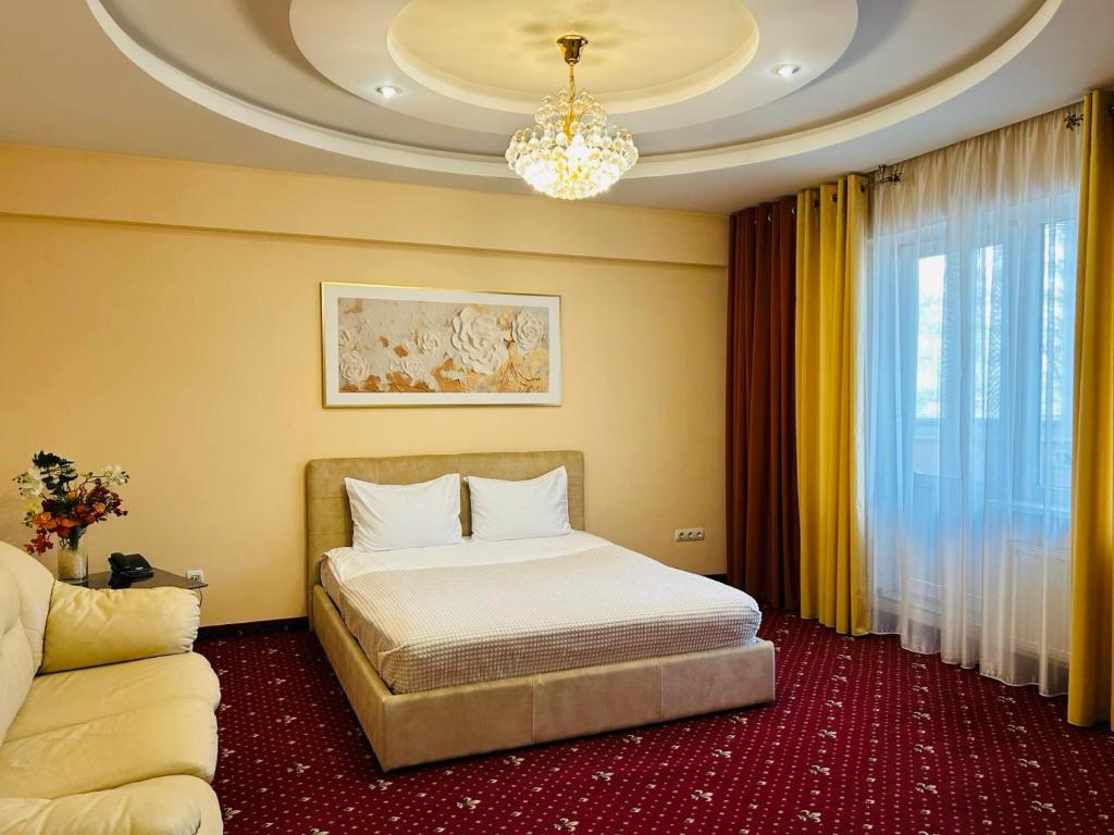 een slaapkamer met een bed en een kroonluchter bij Luxury Apartment in New Building in Chişinău