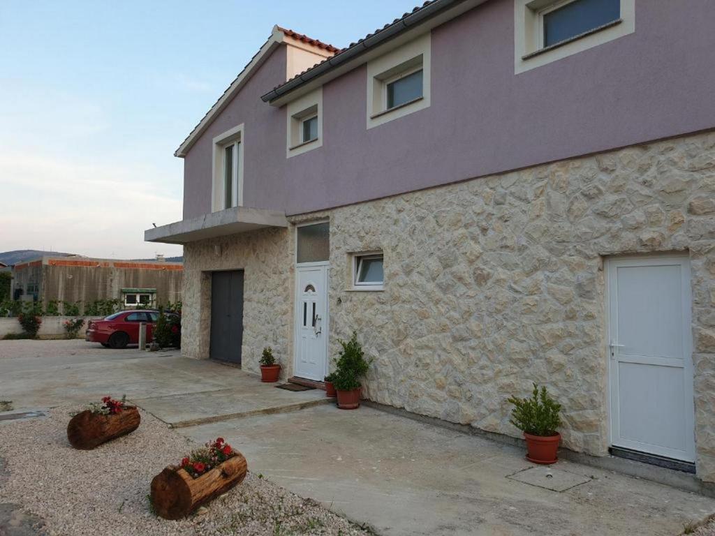 a stone house with two garage doors and some plants at Holiday Home Lucić in Lozovac