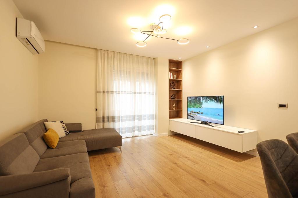 a living room with a couch and a flat screen tv at Grandstay Portside in Durrës