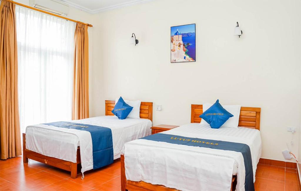 1 dormitorio con 2 camas con sábanas azules y blancas en lotus hotel 2 khách sạn bắc ninh en Bắc Ninh