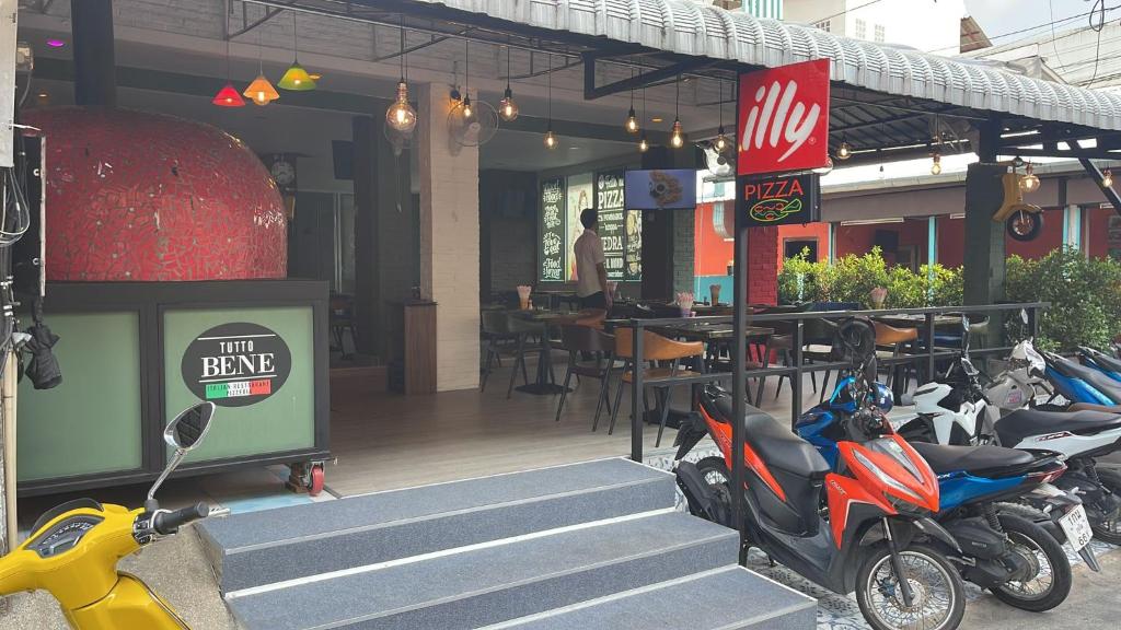 uma fila de scooters estacionadas à porta de um restaurante em PATONG BLUE HOTEL em Patong Beach