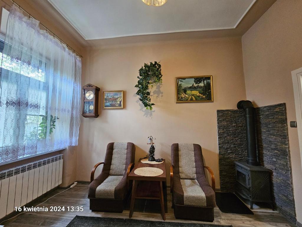 - un salon avec deux chaises, une table et une cheminée dans l'établissement Apartament Studio Old City, à Przemyśl