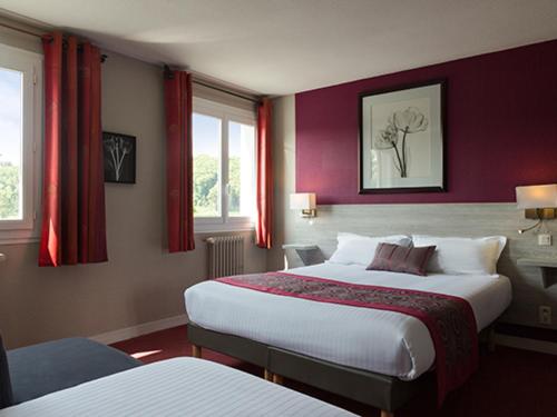 een hotelkamer met 2 bedden en rode muren bij The Originals Boutique, Hôtel Les Quatre Salines, Le Mont Saint-Michel Sud in Roz-sur-Couesnon