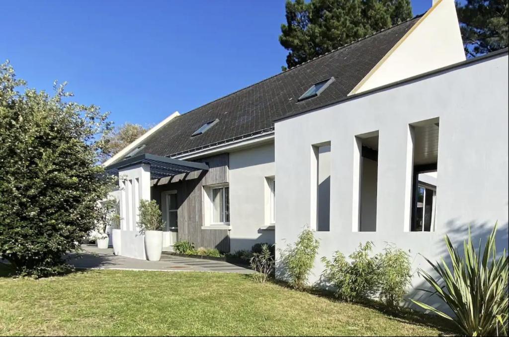 une maison blanche avec un toit noir dans l'établissement Villa Elias, pour séjours familiaux : Spacieuse, moderne, à La Baule