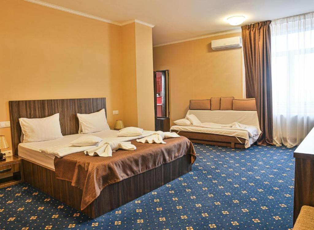 a hotel room with two beds with towels on them at Amy in Oradea