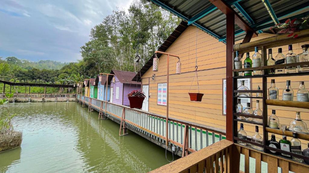 eine Reihe von Gebäuden neben einem Wasserkörper in der Unterkunft Wonderland Cottage in Bentong