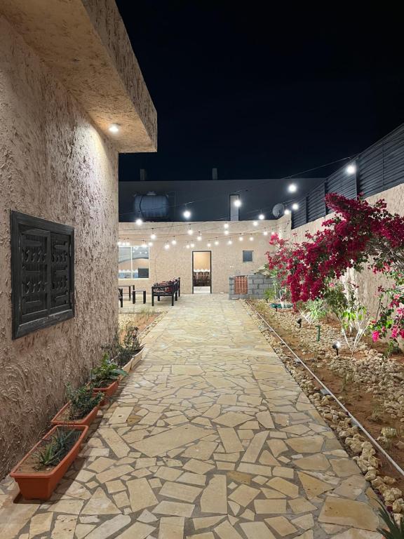 a stone walkway in a building with flowers at شاليهات حائط طيني in Riyadh