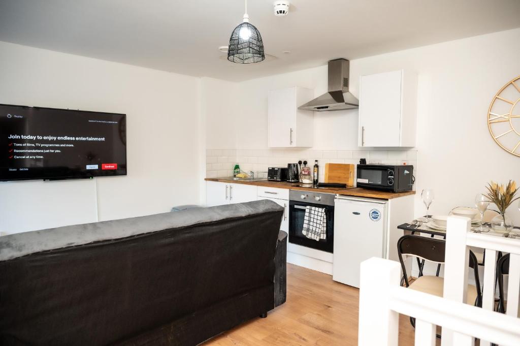 a living room with a couch and a kitchen at Corporate-Friendly 2BR Apartment in Leeds, Near Kirkstall Shopping Centre in Leeds