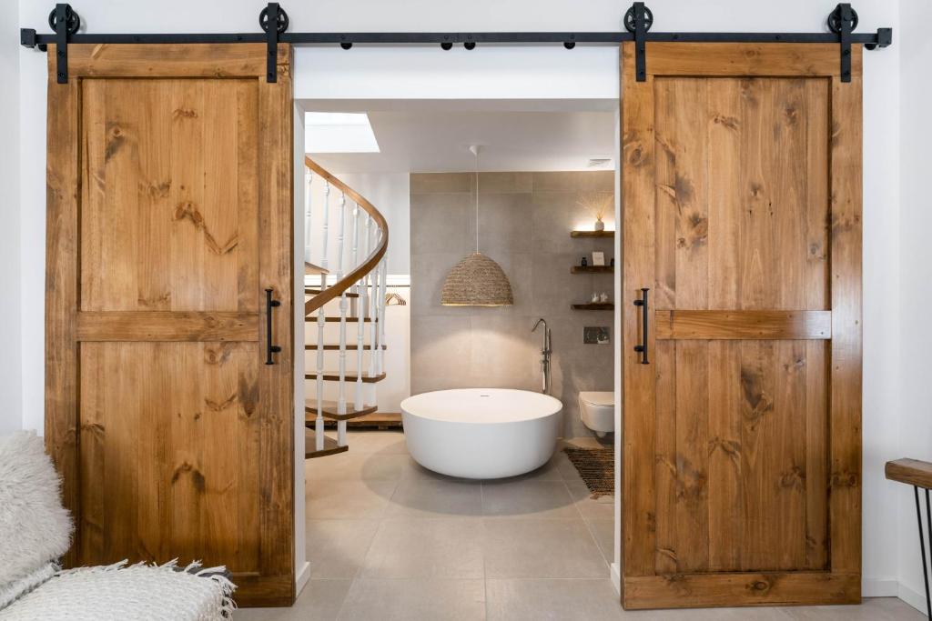 ein Bad mit einer Schiebetür, die zu einer Badewanne führt in der Unterkunft 57 Bee OLD TOWN Lagos - house near beach & Marina in Lagos