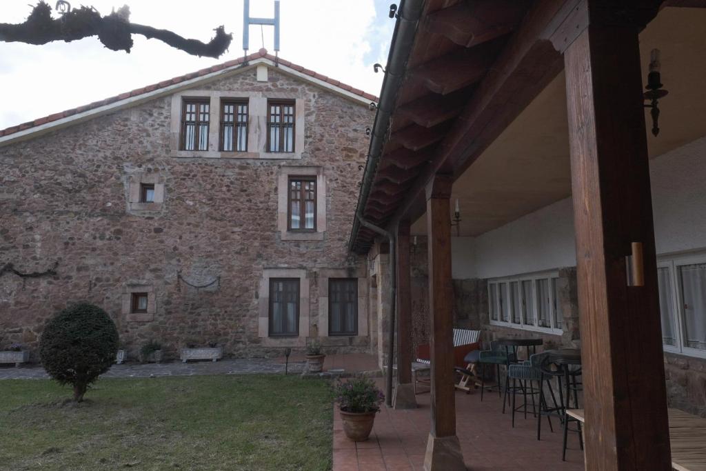 Blick auf ein Backsteingebäude mit einer Terrasse in der Unterkunft Posada la Estela de Barros in Los Corrales de Buelna
