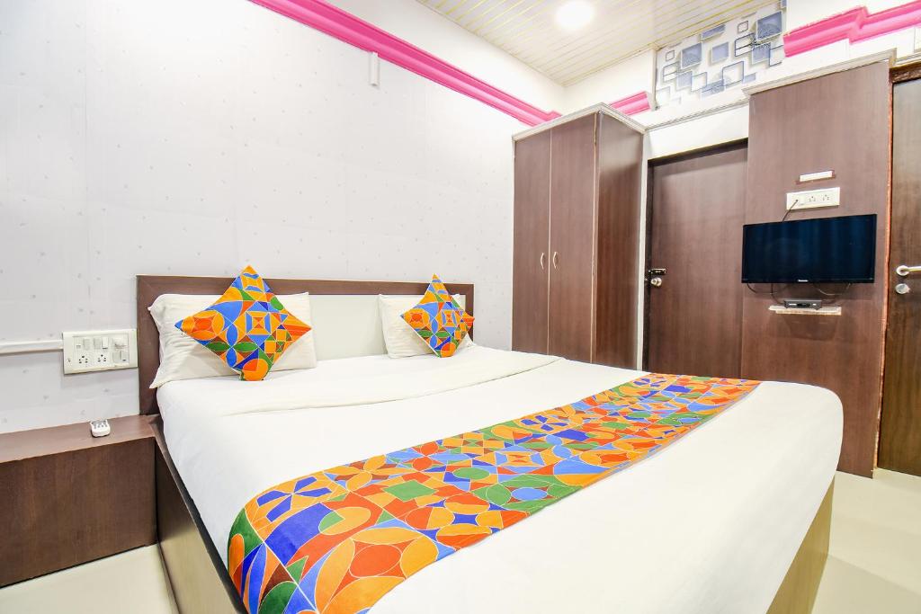 FabHotel The Horizon I في لونافالا: غرفة نوم مع سرير كبير مع بطانية ملونة