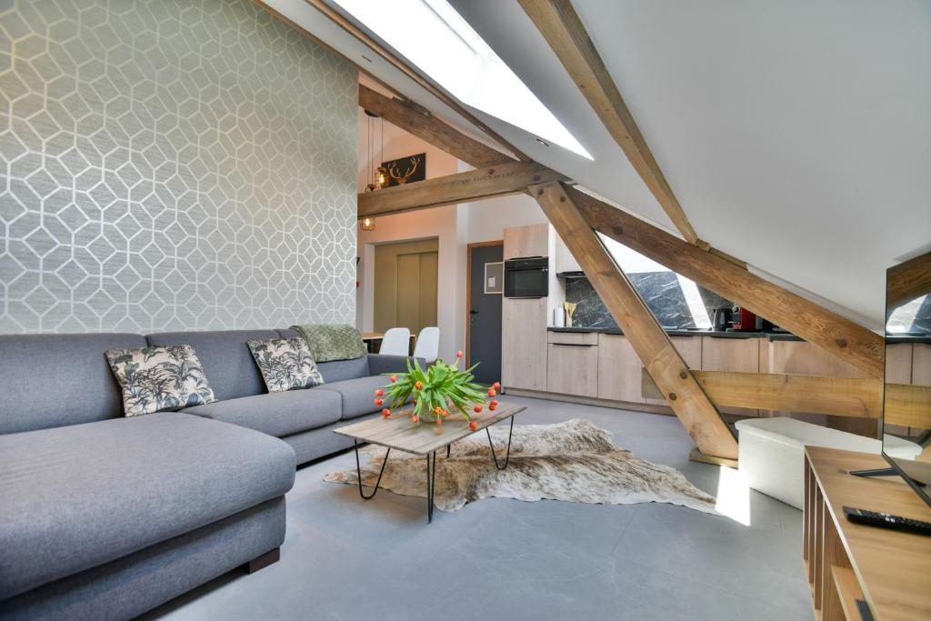 ein Wohnzimmer mit einem Sofa und einem Tisch in der Unterkunft Les Gîtes de Huy - 3 gîtes dans le centre de Huy in Huy