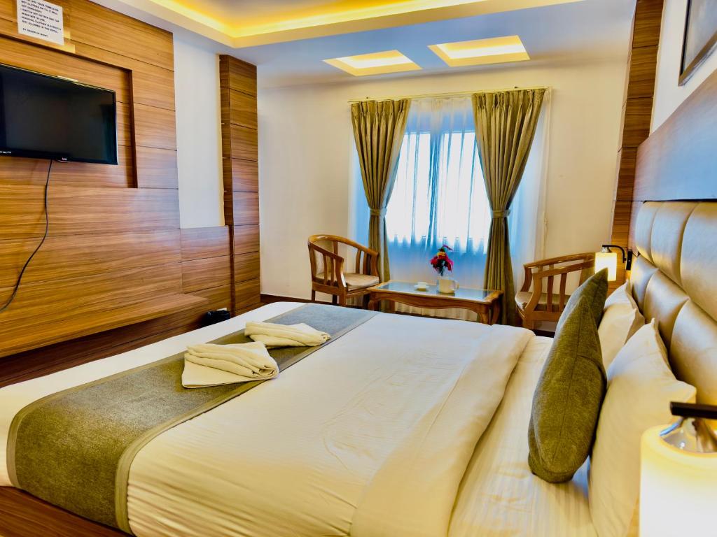 1 dormitorio con 1 cama grande y TV en Staynest darjeeling near railway station en Darjeeling