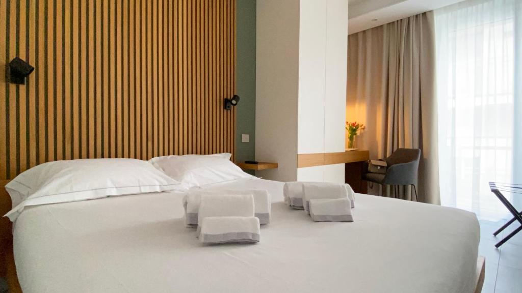 a bedroom with a large white bed with two chairs at ToSuite - Alba Moretta in Alba