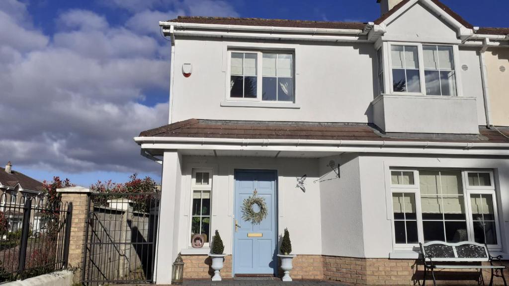 una casa blanca con una puerta azul en El Roi Guesthouse, en Waterford