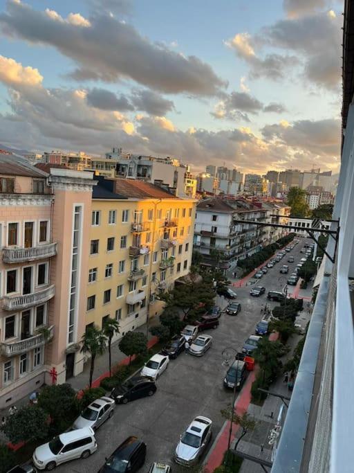 a city street with cars parked in a parking lot at 3 minutes walk from the sea in Batumi