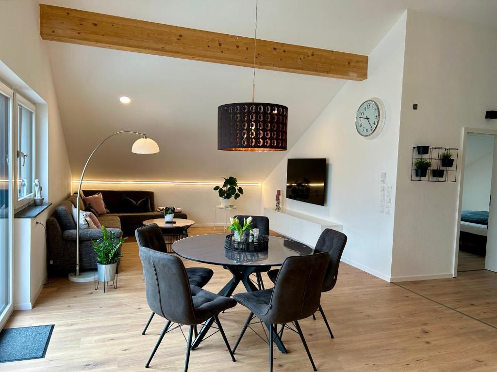 a living room with a dining room table and chairs at Allgäu Zimmer LeAndi in Memmingen