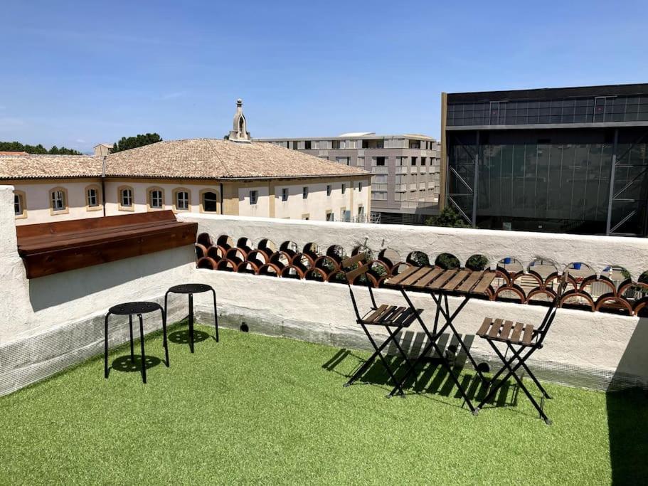 una mesa y sillas en la parte superior de un edificio en Duplex rare avec terrasse vue à 360 Théâtre, en Orange