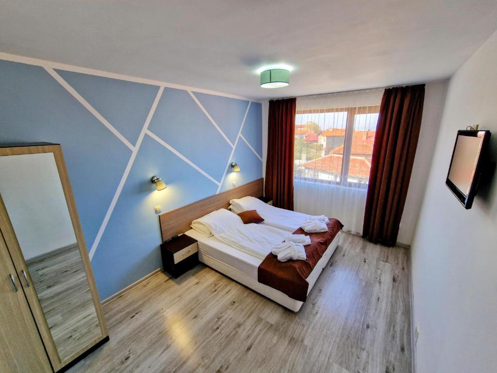 - une chambre avec un lit et une grande fenêtre dans l'établissement Sapareva Apartments, à Sapareva Banya