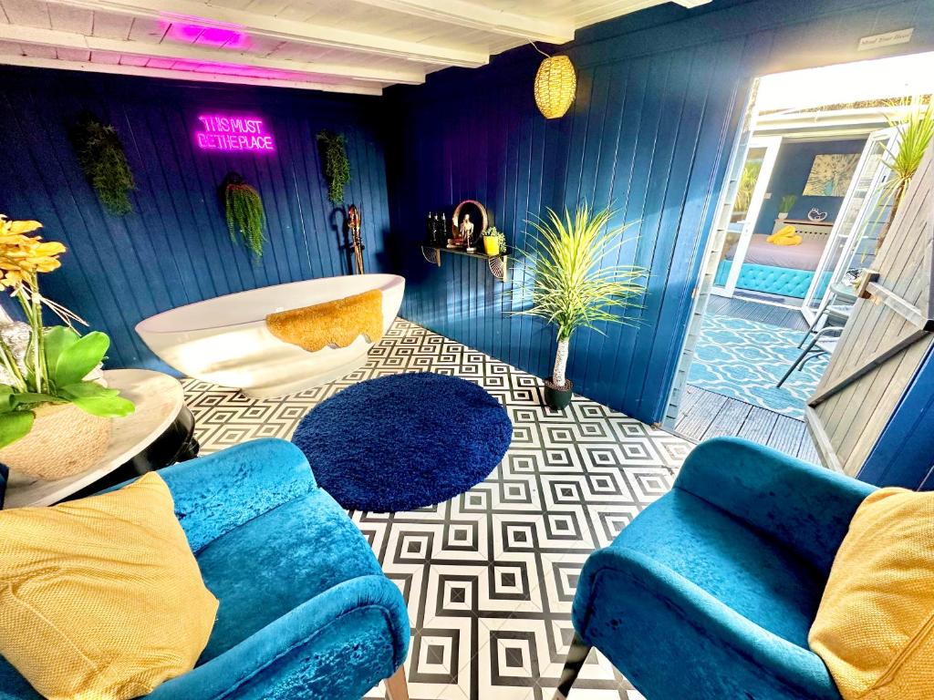 a blue room with a tub and a couch at A Hidden Gem With Private Hot Tub and Garden - Netflix - Fast Wifi - Free Parking in Bournemouth