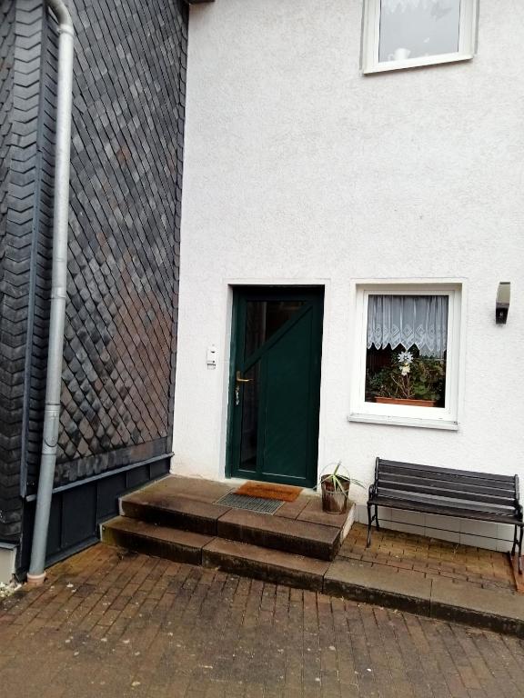 une porte menant à un bâtiment avec un banc et une fenêtre dans l'établissement Ferienwohnung Taube, 