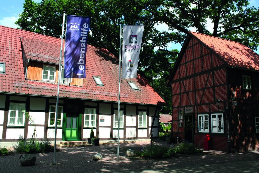 un edificio con dos banderas delante en Hotel Am Kloster, en Wienhausen