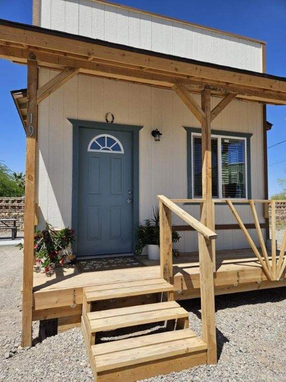 QuartzsiteTiny Cabin #19 American Trails的一座带蓝色门和木门廊的房子