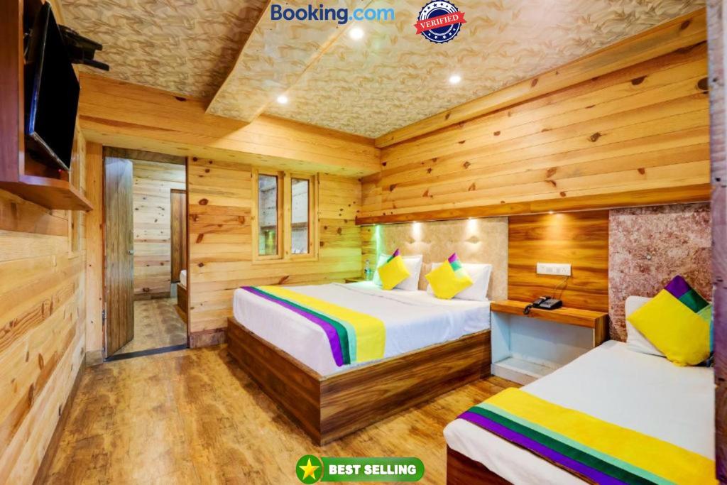 1 Schlafzimmer mit 2 Betten in einem Blockhaus in der Unterkunft Goroomgo Vinayak Mall Road Lake View Nainital - Luxury Room - Best Hotel in Nainital in Nainital