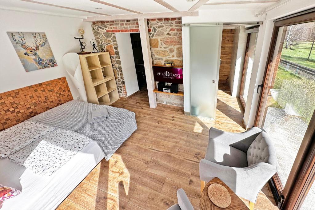 ein Zimmer mit einem Bett und einem Stuhl darin in der Unterkunft Ameisenberg Appartement für Bahnfans in Kurort Oybin