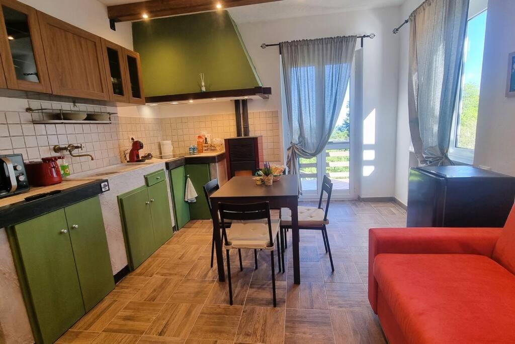 a kitchen with green cabinets and a table and chairs at Bee Freeride Biker house in Rialto